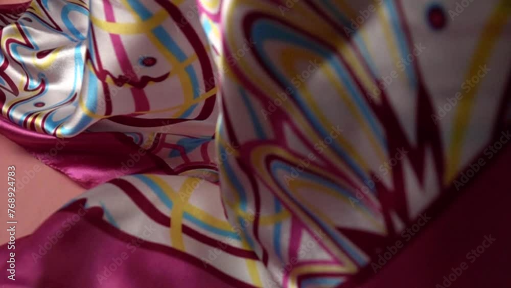 Satin white-pink shawl falls on the pink fabric, slow motion Satin white-pink shawl falls on the pink fabric, slow motion