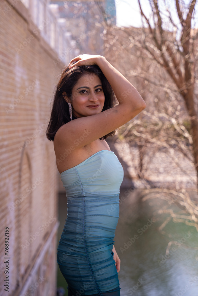 A woman in a blue dress is posing for a picture