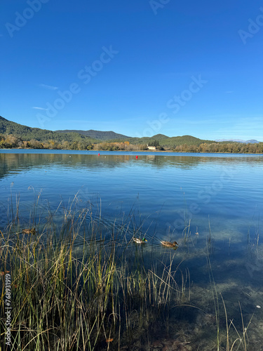 Paseo por el estanque de Banyoles, con barcas de madera amarradas. Cataluña. España.