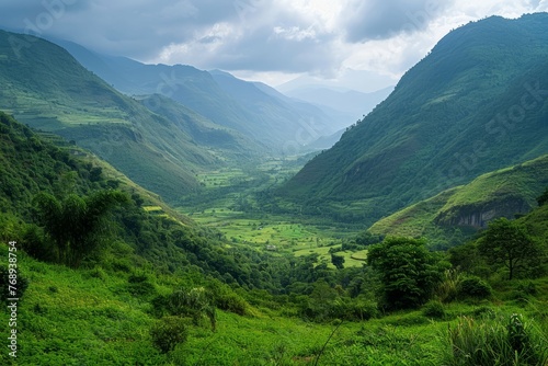 Lush green valley with rolling hills under a cloudy sky.