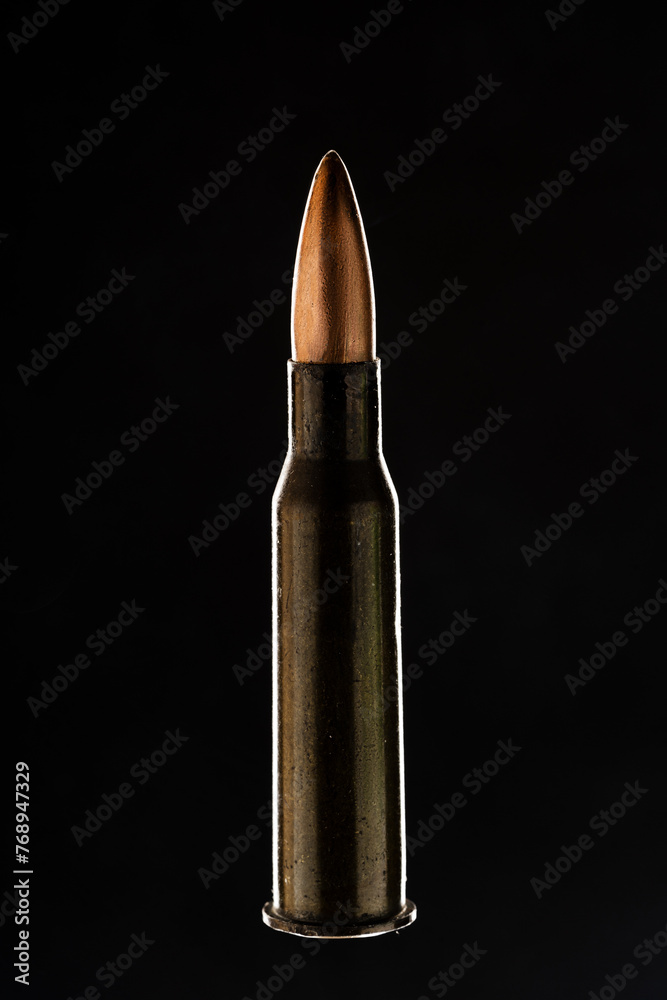 Rifle bullet long cartridge on black background. Army or hunting weapon shot object, violence and danger symbol. Rifle bullet long cartridge on black background. Army or hunting weapon shot object, violence and danger symbol.