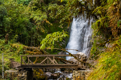 A waterfall with wooden bridge in Thangyam Village of Taplejung, Kanchenjunga Trek, Nepal photo