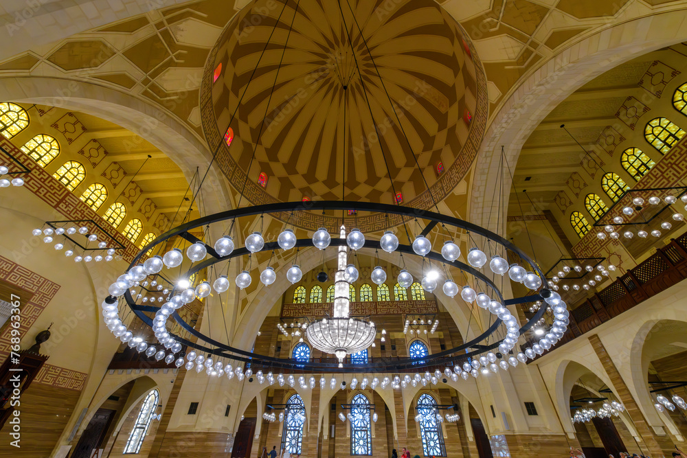 Obraz premium Interior view of the dome, ceiling and large hanging light fixture chandelier inside the Al Fateh Grand Mosque, in Manama, Bahrain.