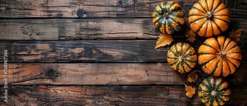   A wooden table supports an assortment of pumpkins - orange, green, and stacked atop photo
