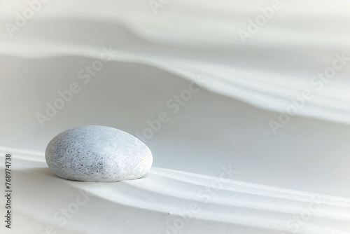 A lone pebble resting on a bed of smooth  white sand  with gentle waves lapping at the shore in the background