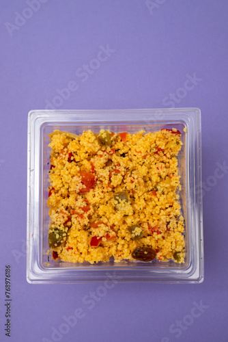Delicious vegetarian couscous with tomatoes, carrots, zucchini, yellow bell pepper in plastic box