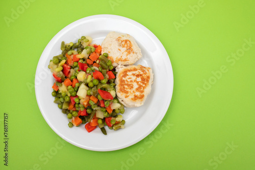 Roasted chicken cutlets with vegetables on white plate