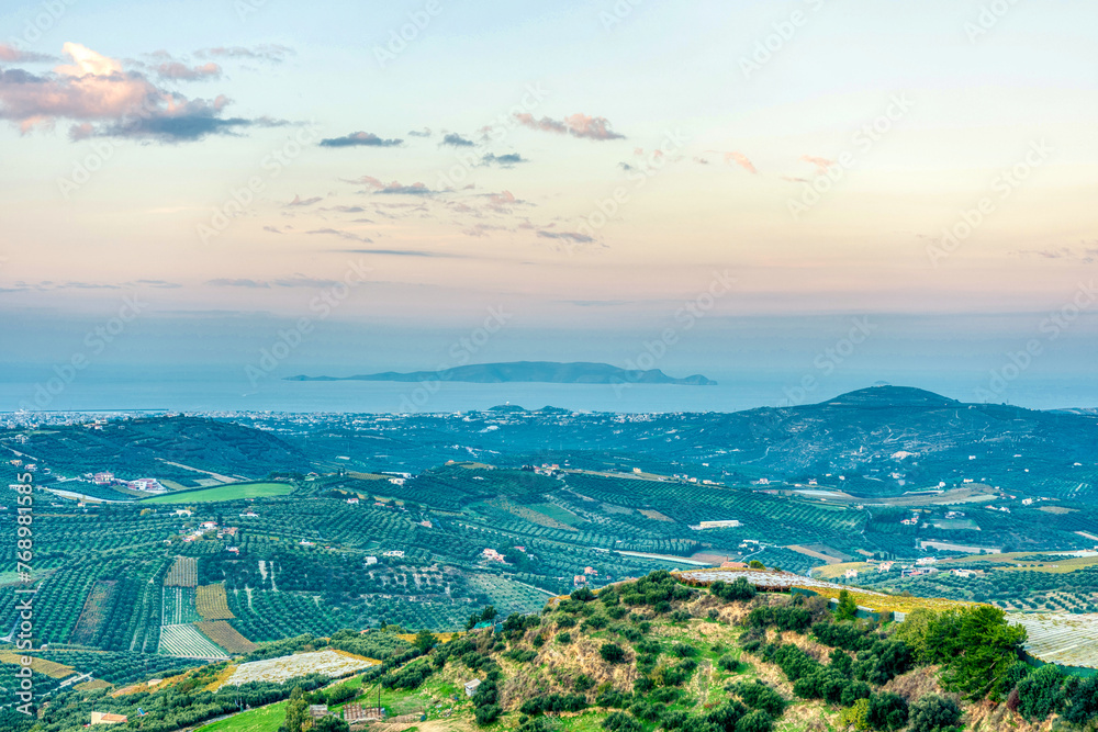Beautiful view of landscape with olive trees and mountains on Crete island during sunset.