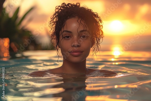 A woman enjoys a tranquil swim at sunset, with the sky ablaze in warm colors.