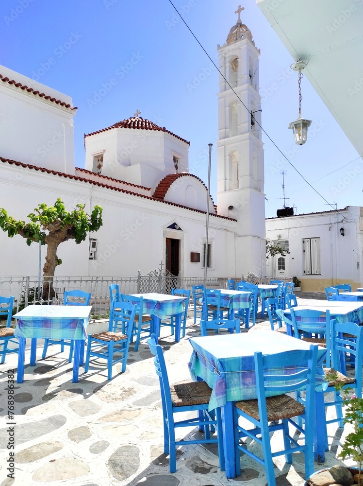 Obraz premium Photo of a traditional Greek tavern outside the Church of Virgin Malamatenia on the Cycladic island of Tinos, Greece.