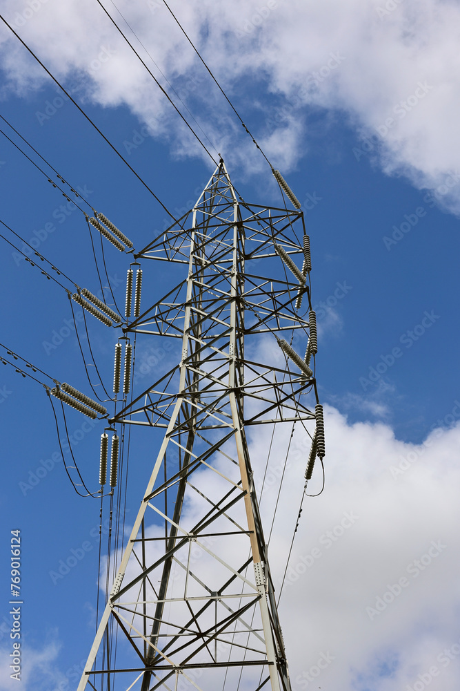 Tall steel pylon supporting multiple power lines