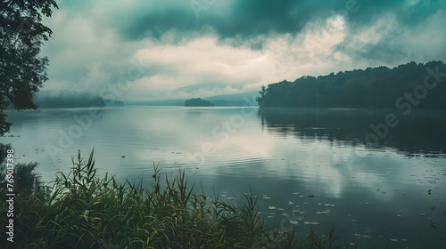Misty Lake Surrounded by Lush Forest at Dusk with Dramatic Cloudy Sky and Serene Reflection