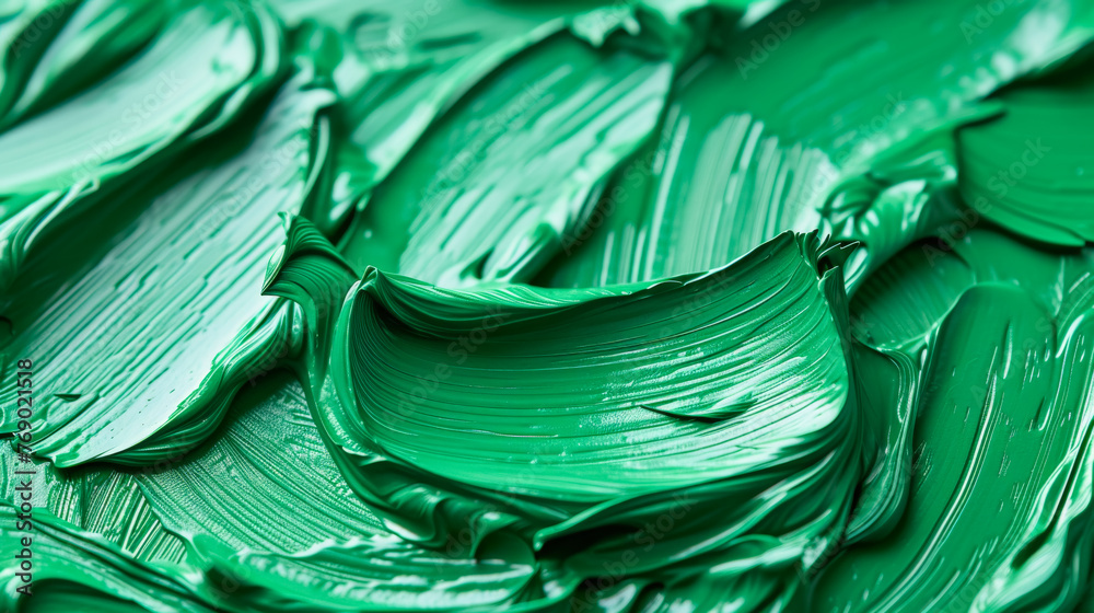 The green paint is thick and has a lot of texture. It looks like it was applied with a brush or a palette knife. The green color is vibrant and bold, and it seems to be the main focus of the painting