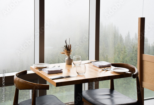 Modern style table set at a restaurant ready for customers in front of large window