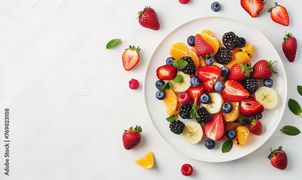 Sliced fruits and berries on plate on white table, with empty copy space