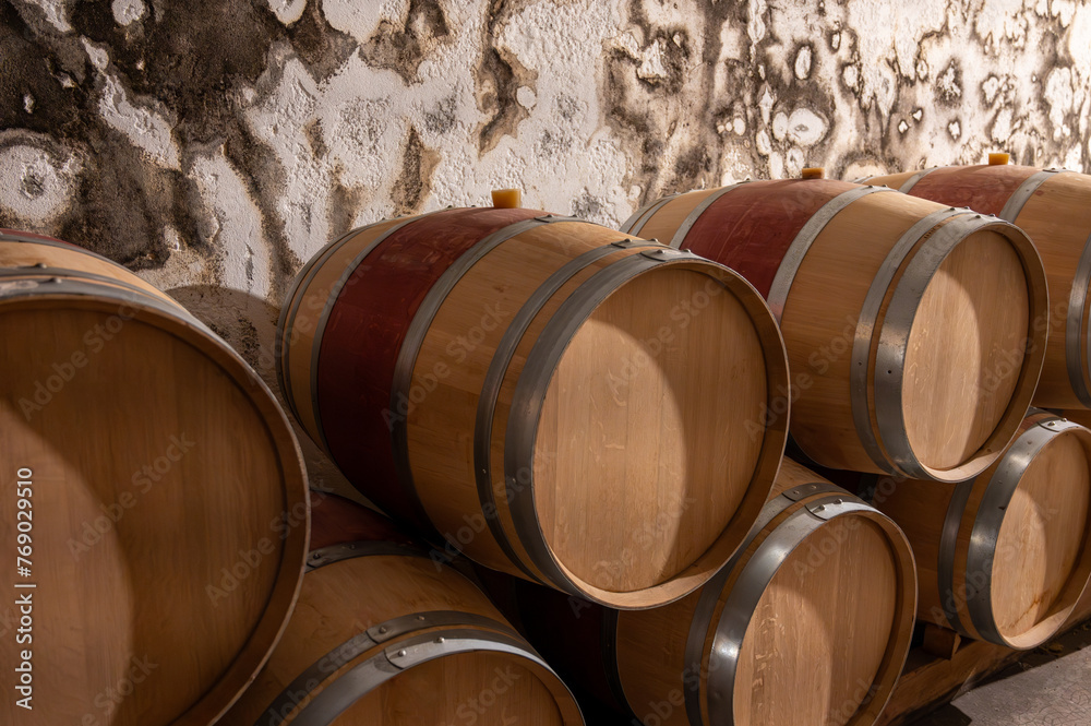 French oak wooden barrels for aging red wine in underground cellar, Saint-Emilion wine making region picking, cru class Merlot or Cabernet Sauvignon red wine grapes, France, Bordeaux French oak wooden barrels for aging red wine in underground cellar, Saint-Emilion wine making region picking, cru class Merlot or Cabernet Sauvignon red wine grapes, France, Bordeaux