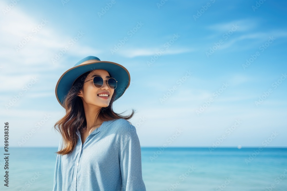 Beautiful Happy young Asian tourist woman wearing a beach hat, and sunglasses, going to travel on holiday on a blue sky background. travel concept. Beautiful Happy young Asian tourist woman wearing a beach hat, and sunglasses, going to travel on holiday on a blue sky background. travel concept.