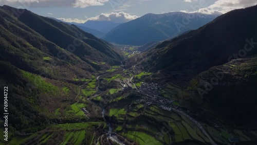 Flying a drone over a village in the Basque Country, Spain, moving forward over terraced fields located between forested mountains photo