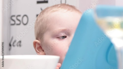 Happy cute preschool boy using tablet and eat grape