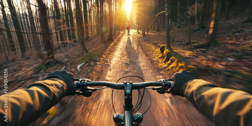 First person view of men riding bicycle in woodland path on sunny summer day. Athlete on his bike in summer forest.