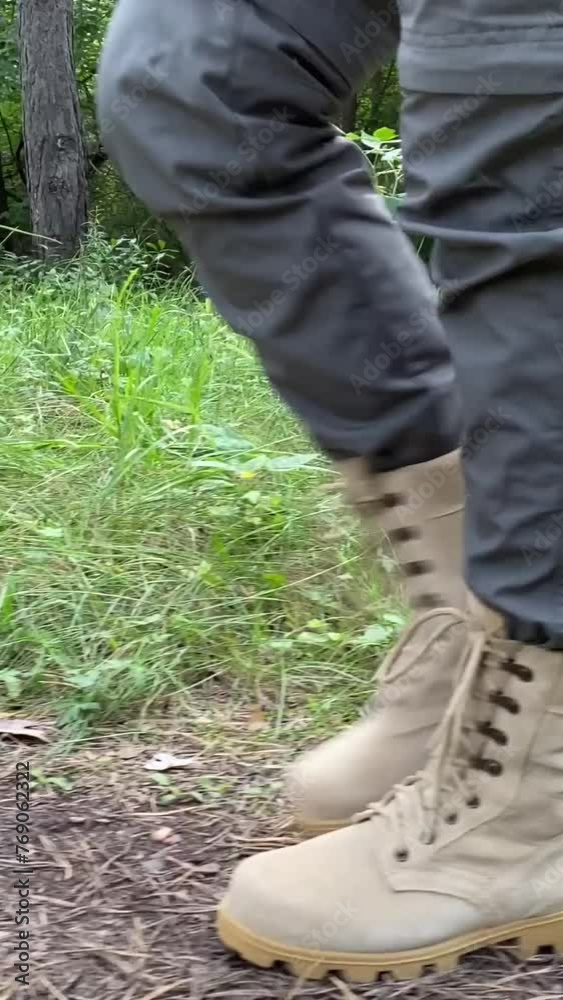 The woman is engaged in hiking in a pine forest. close-up of legs. Vertical video. The woman is engaged in hiking in a pine forest. close-up of legs. Vertical video.