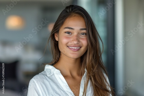 A woman with long brown hair is smiling at the camera