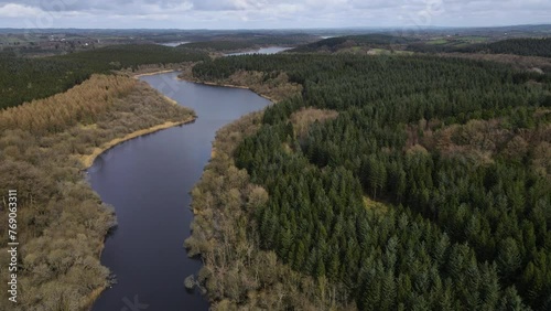 A high drone shot showing a twisty lake through a forest in the Irish countryside on an overcast day. Dromore Lough, Dartrey Forest, Cavan and Monaghan. photo