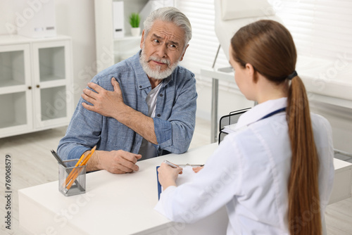 Arthritis symptoms. Doctor consulting patient with shoulder pain in hospital