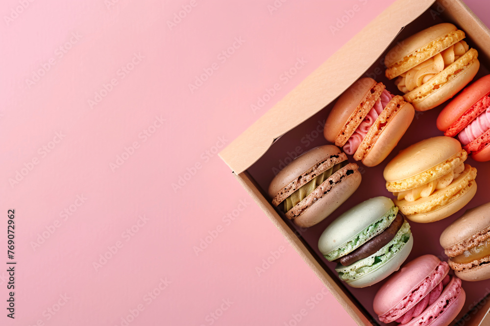 © Di Studio - colorful macarons in the cardboard box on the pink background with copy space