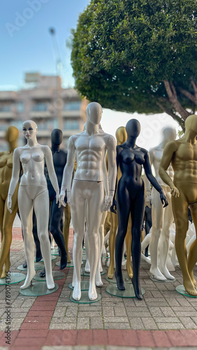 A diverse lineup of mannequins in different finishes stands poised against an urban backdrop, creating a striking scene for fashion display.
