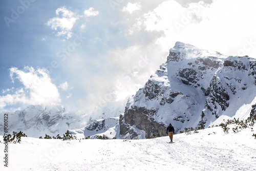 samotny wędrowiec na tle skalistego szczytu w górach zimą, Kościelec, Tatry © sarns