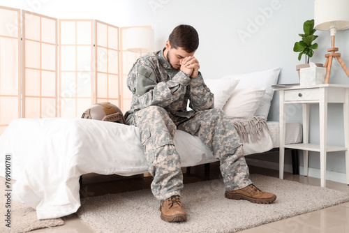 Young male soldier praying in bedroom © Pixel-Shot