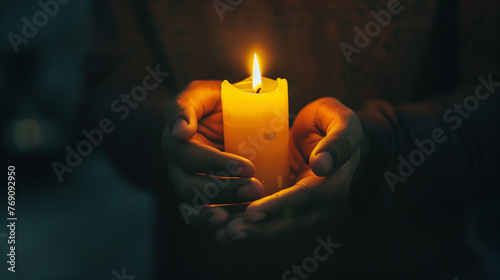 A person holding a candle in a dark room, symbolizing faith as a guiding light in times of darkness 