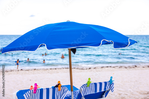 Against the stunning backdrop of Miami Beach, beach towels secured with colorful clips sun loungers. USA.