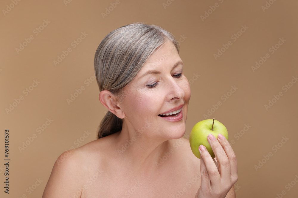 Beautiful woman with fresh apple on beige background. Vitamin rich food Beautiful woman with fresh apple on beige background. Vitamin rich food