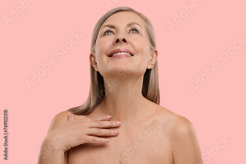 Beautiful woman with healthy skin on pink background