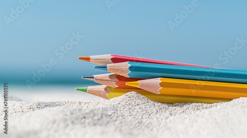 Pens laid on the sand, show the end of the school year and the beginning of the summer break. Summer holiday. Copy space. Horizontal.  photo