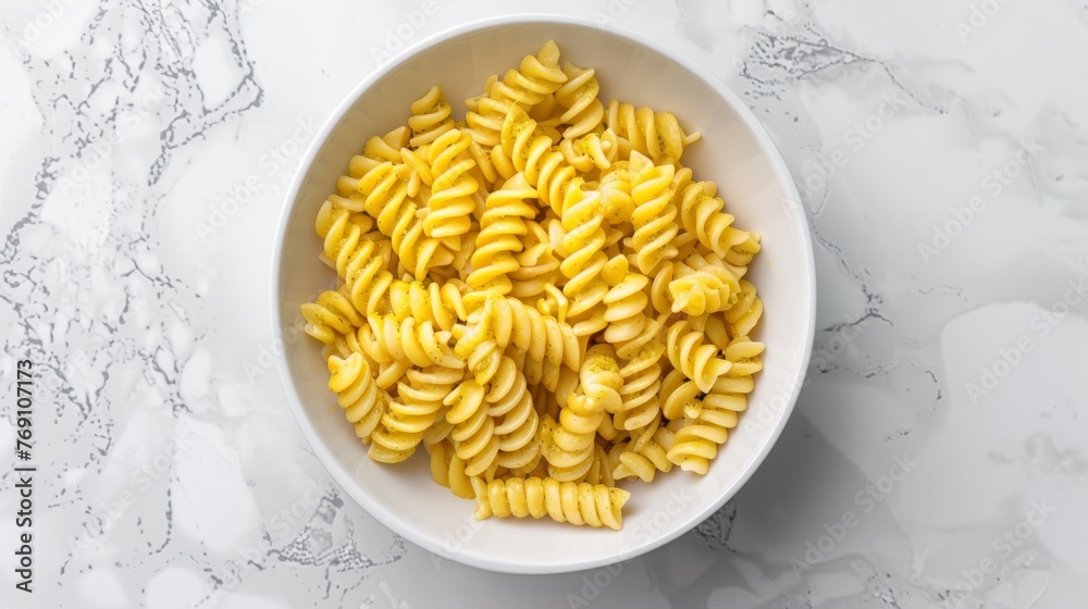 a bowl of macaroni and cheese sitting on a marble counter top next to a white marble counter top. a bowl of macaroni and cheese sitting on a marble counter top next to a white marble counter top.