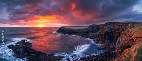 A dramatic sunset sky unfurls over sheer sea cliffs, casting a fiery glow over the ocean's rhythmic waves..
