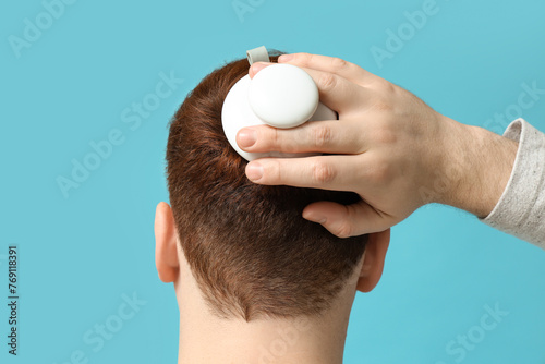 Young man using hair scalp ...