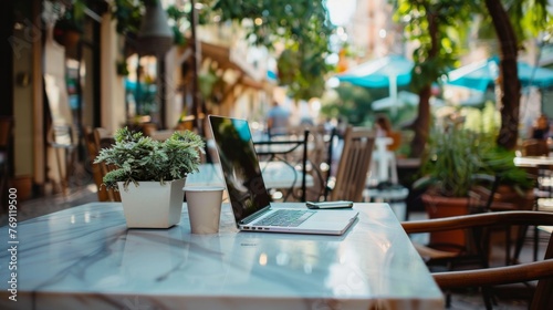 Outdoor Cafe Setting With Laptop and Smartphone on Table Daytime