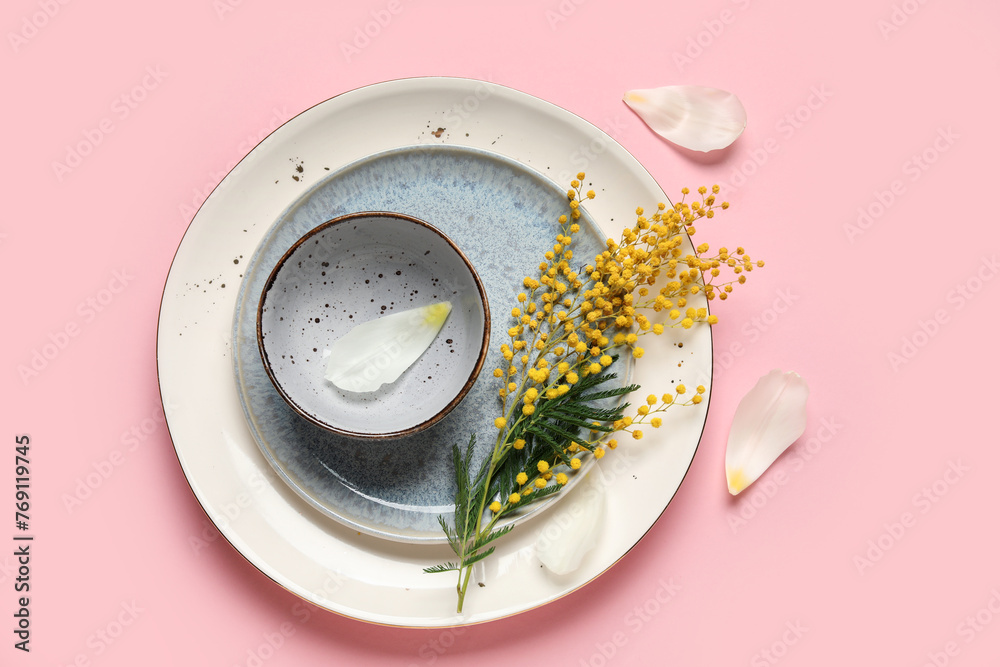 Beautiful table setting with mimosa flowers and petals on pink background