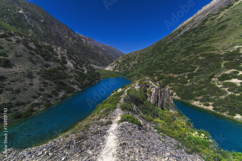 Lake with blue clear clear water in the mountains in summer. Koksai Ainakol Lake in Tien Shan Mountains in Asia in Kazakhstan