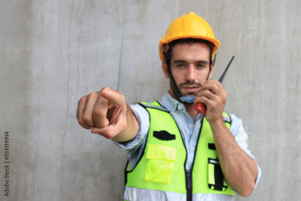 The gesture of a male engineer posing with a walkie-talkie. Strike a pose of a male engineer using a walkie-talkie. The gesture of a male engineer posing with a walkie-talkie. Strike a pose of a male engineer using a walkie-talkie.