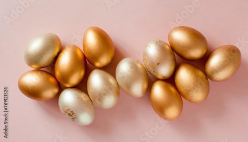 golden easter eggs on pastel pink background top view