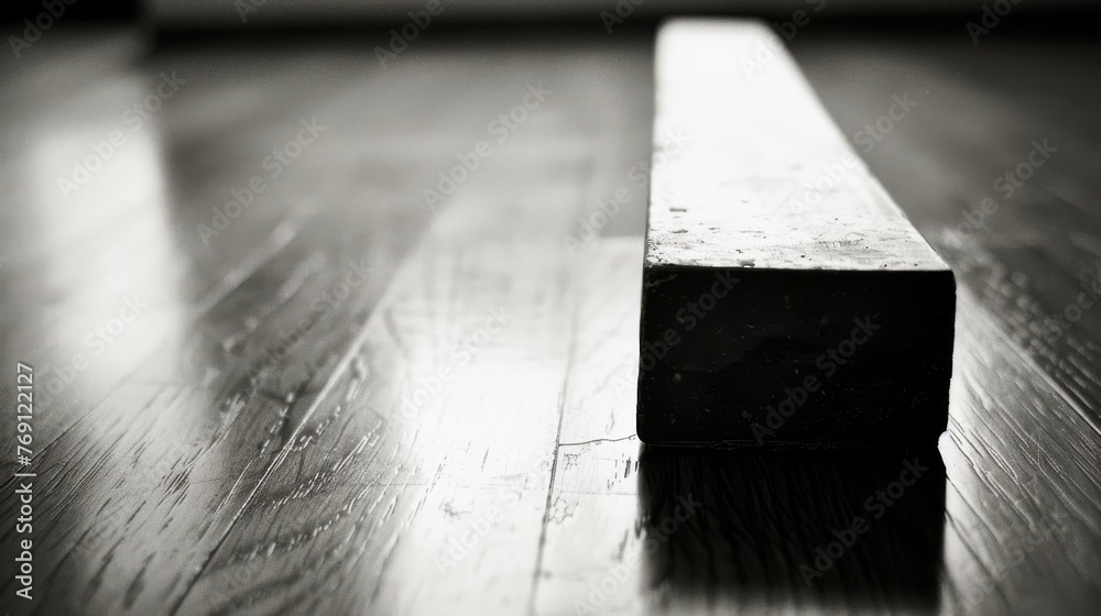 Black-and-white picture of wooden planks featuring a rectangular item positioned atop Black-and-white picture of wooden planks featuring a rectangular item positioned atop