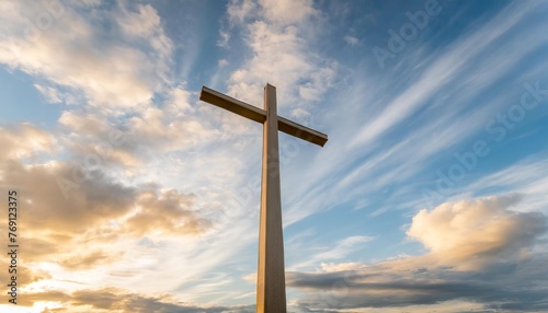 christian cross appears bright in the blue clloudy sky background photo