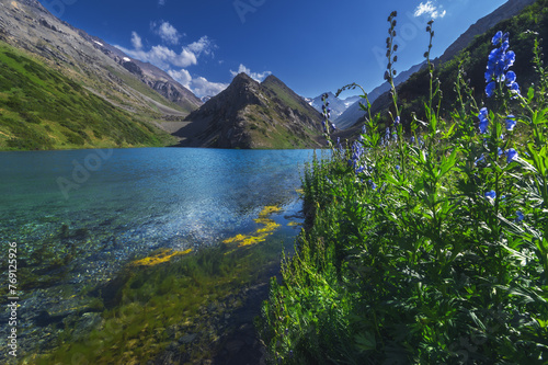 Lake with blue clear clear water in the mountains in summer. Koksai Ainakol Lake in Tien Shan Mountains in Asia in Kazakhstan