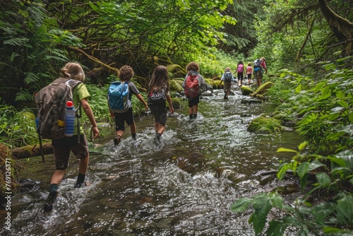 A diverse group of children and adults crossing a river in a forest setting
