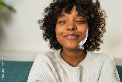 Beautiful African American girl with afro hairstyle smiling. Close up portrait of young happy black girl. Young African woman with curly hair laughing. Freedom happiness carefree happy people concept